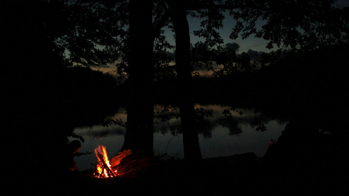 Abenddämmerung und Lagerfeuer am See.